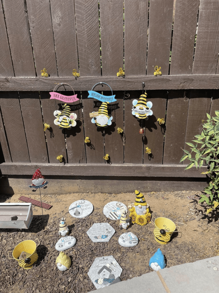 A garden area decorated with DIY bee decorations and other garden ornaments.