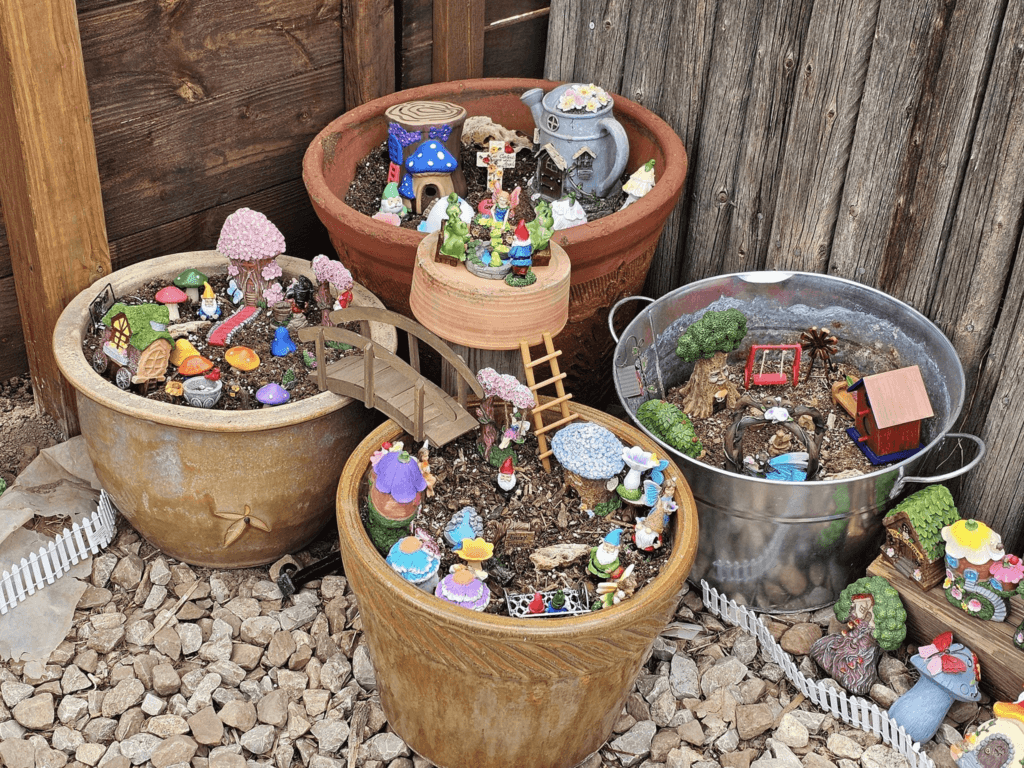 Detailed view of the gnome and fairy garden, showcasing miniature scenes and colorful figurines.