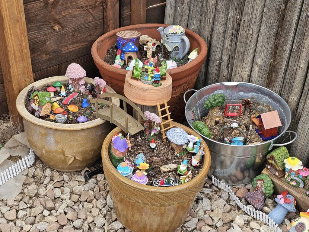Detailed view of the gnome and fairy garden, showcasing miniature scenes and colorful figurines.