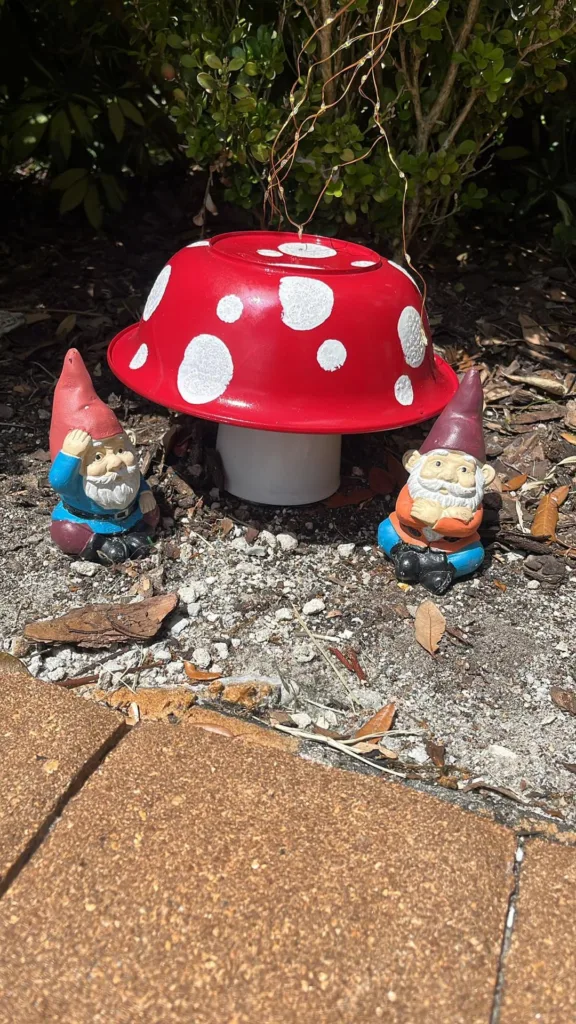 DIY mushroom decoration with gnomes made from Dollar Tree items.