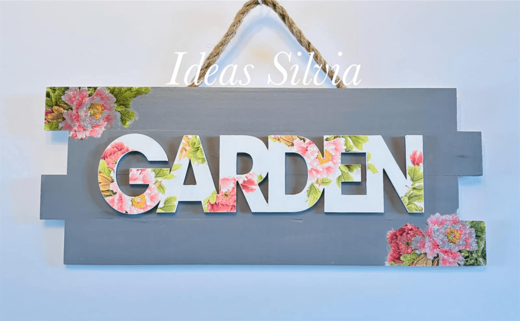 DIY garden sign made from wooden boards and decorated with floral napkins.