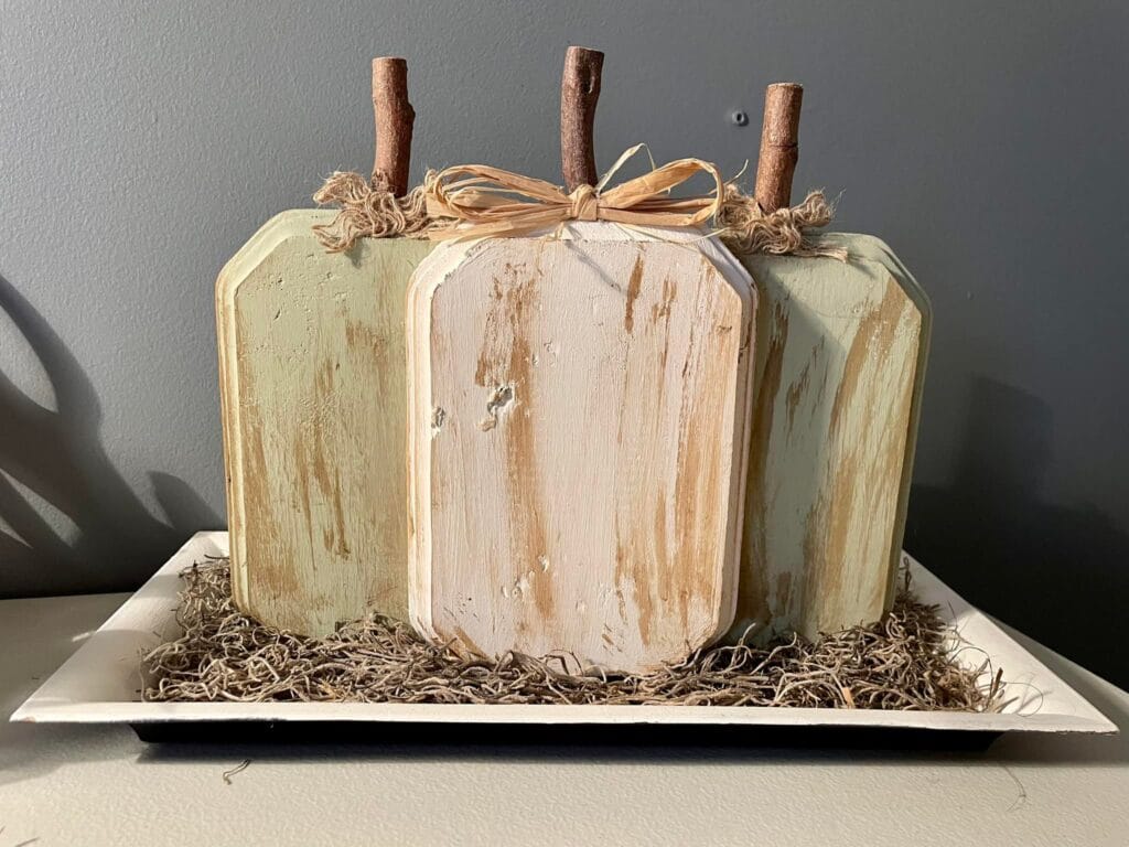 Rustic fall centerpiece made with Dollar Tree cutting boards painted like pumpkins