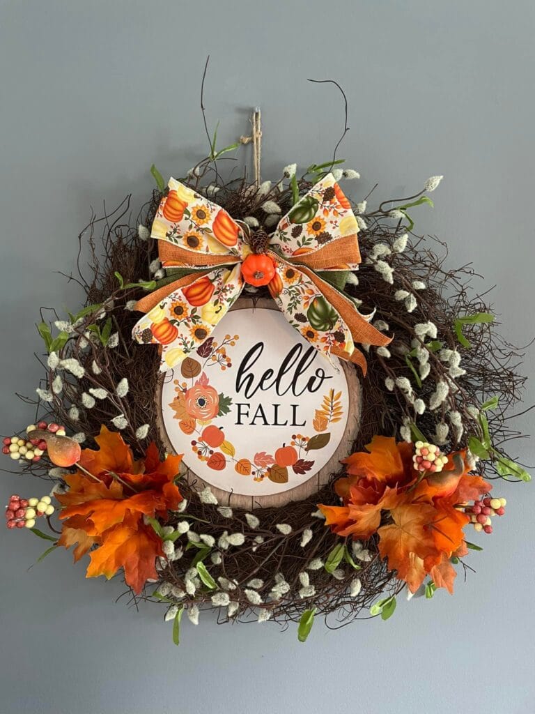 Colorful fall door wreath with Hello Fall sign, faux leaves, and decorative bow