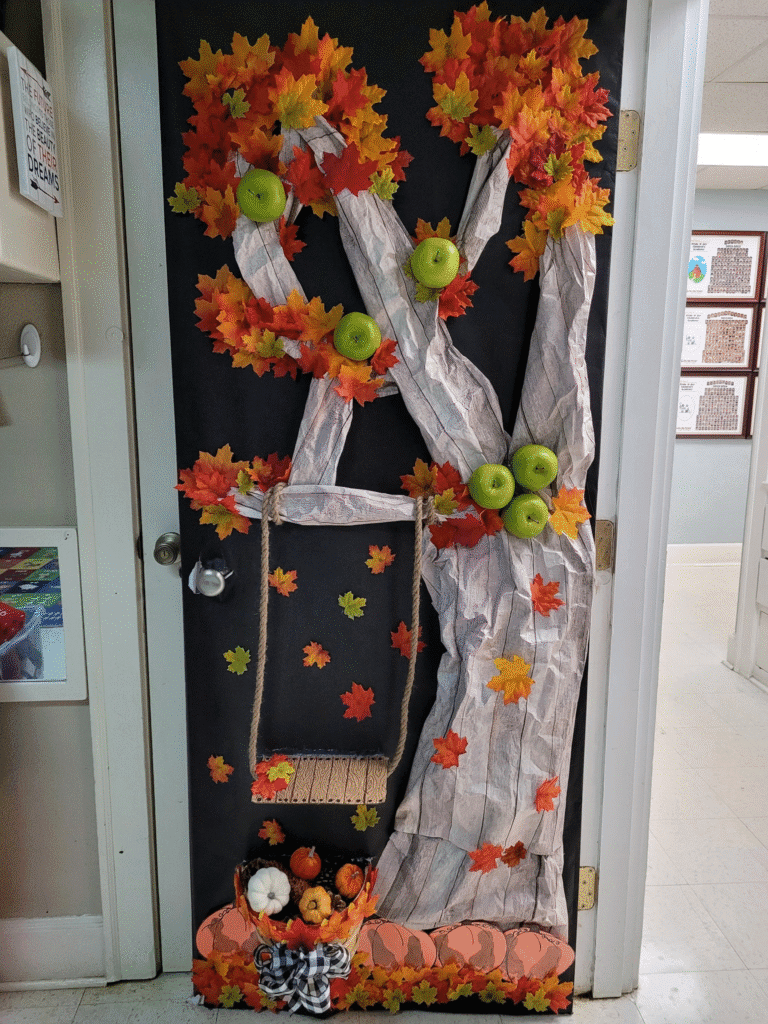 DIY scarecrow fall door decoration with faux flowers, greenery, and long hanging ribbons in fall colors
