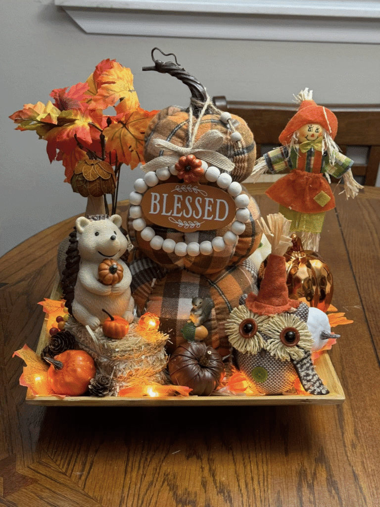 Fall table centerpiece with plaid pumpkins, Blessed sign, woodland animals, autumn leaves, and string lights